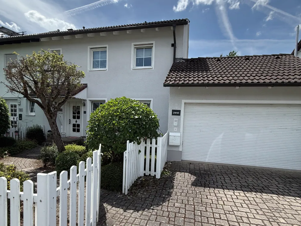 Verkauftes Einfamilienhaus mit weißem Gartenzaun und Doppelgarage